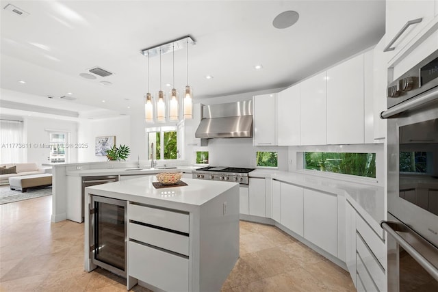 455 Centre Is, Golden Beach, FL 33160 - kitchen featuring a sink, wall chimney exhaust hood, wine cooler, visible vents, and modern cabinets