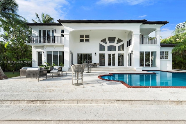 455 Centre Is, Golden Beach, FL 33160 - rear view of property with french doors, a patio area, an outdoor pool, and a balcony