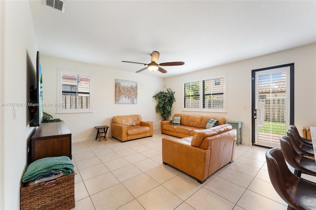 living area with a ceiling fan, light tile patterned flooring, baseboards, and visible vents