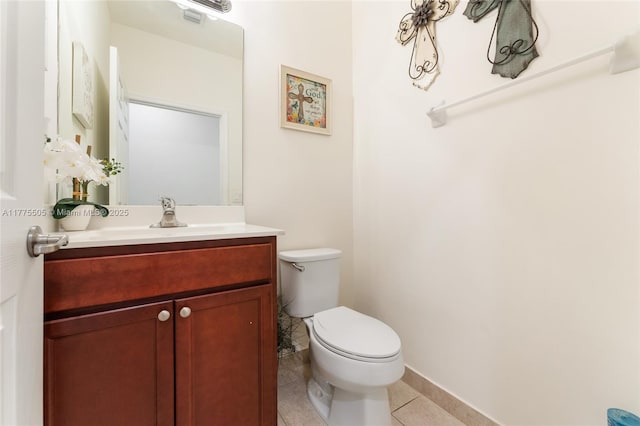 bathroom featuring tile patterned floors, toilet, baseboards, and vanity