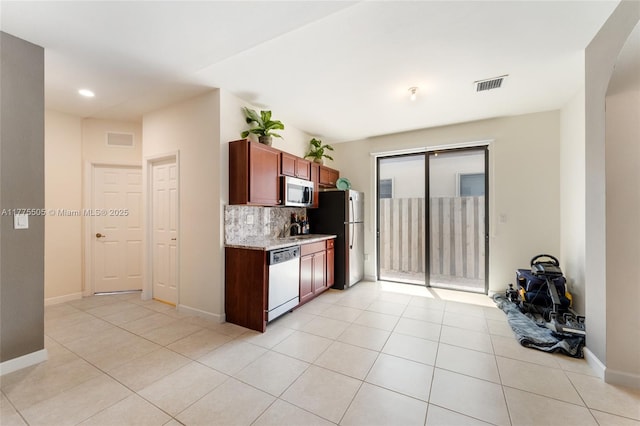 kitchen featuring light tile patterned flooring, visible vents, backsplash, and appliances with stainless steel finishes