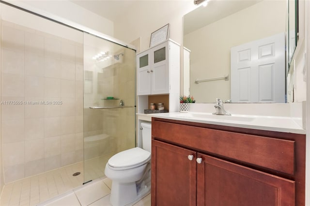 bathroom with toilet, vanity, a stall shower, and tile patterned flooring