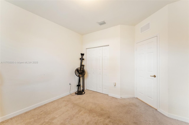 spare room with carpet flooring, baseboards, and visible vents