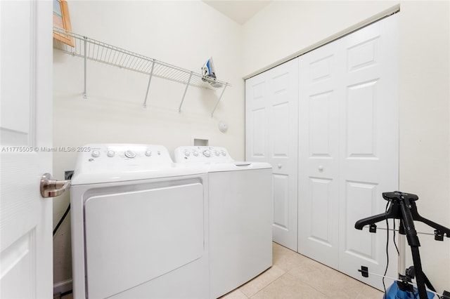 washroom featuring light tile patterned floors, washing machine and dryer, and laundry area