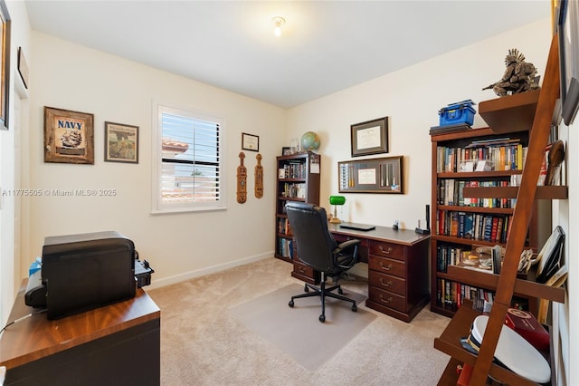 office space featuring light carpet and baseboards