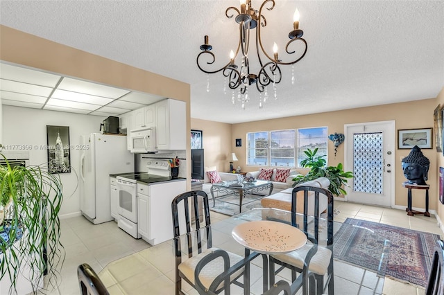 dining space with baseboards, light tile patterned flooring, a chandelier, and a textured ceiling