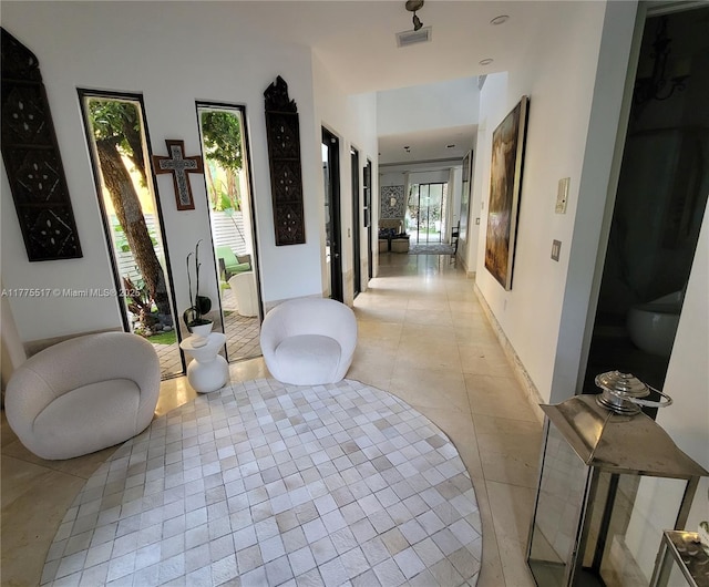 hall with light tile patterned flooring and visible vents