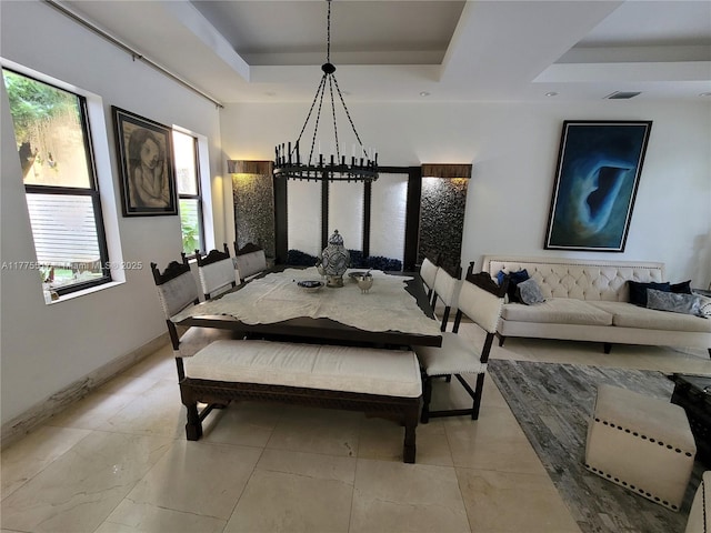 dining room with a tray ceiling, baseboards, and visible vents