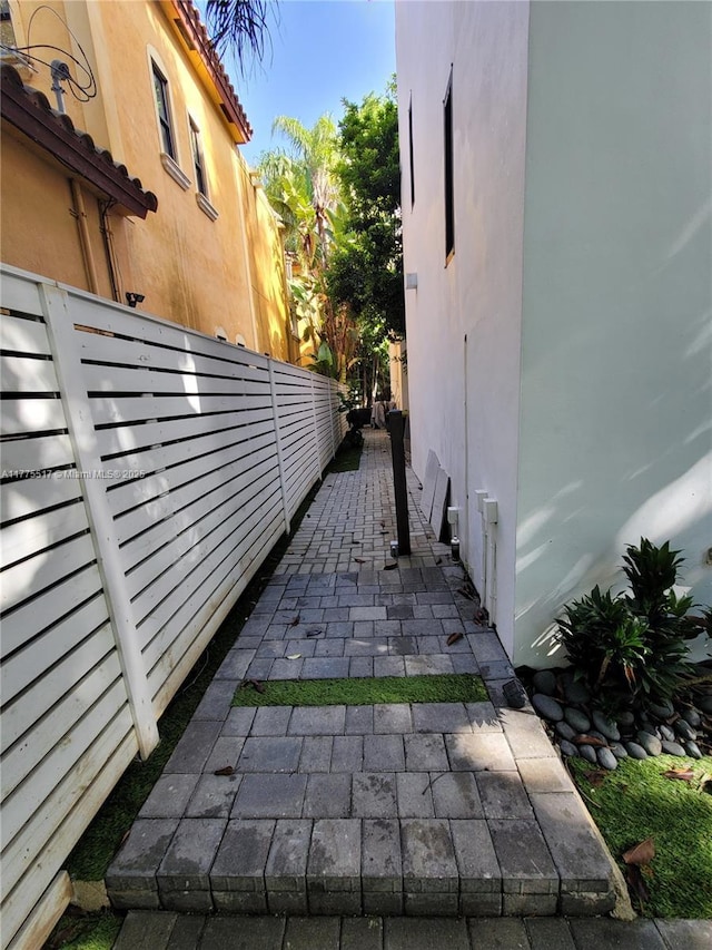 view of property exterior with a tile roof, stucco siding, fence, and a patio
