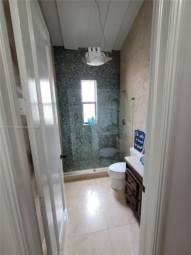 bathroom featuring a shower stall, toilet, and tile patterned flooring