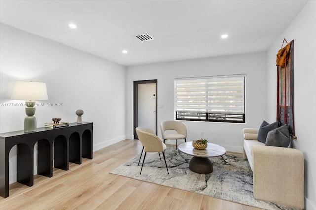 living room featuring recessed lighting, wood finished floors, visible vents, and baseboards