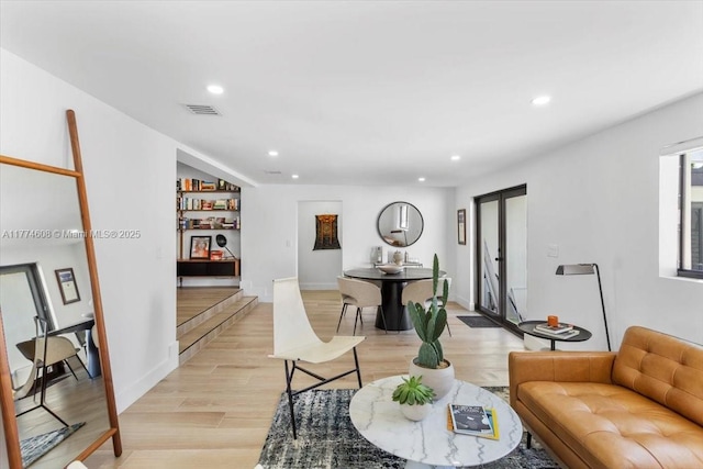 living area featuring light wood-type flooring, visible vents, and recessed lighting