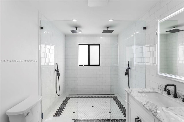bathroom featuring tile walls, vanity, a shower stall, and toilet
