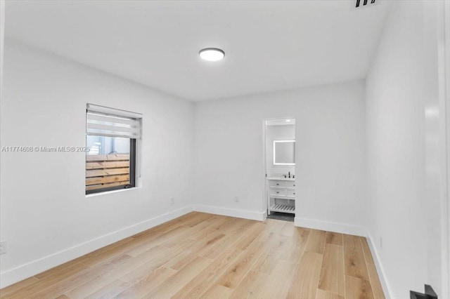 unfurnished room featuring baseboards and light wood-style floors