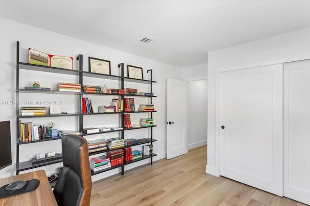 office space with light wood-style floors and visible vents