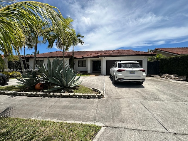 view of front facade featuring a tiled roof, stucco siding, a garage, and concrete driveway