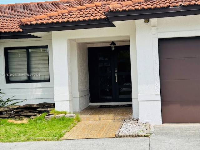 20785 SW 129th Ct, Miami, FL 33177 - property entrance with a tiled roof, french doors, a garage, and stucco siding