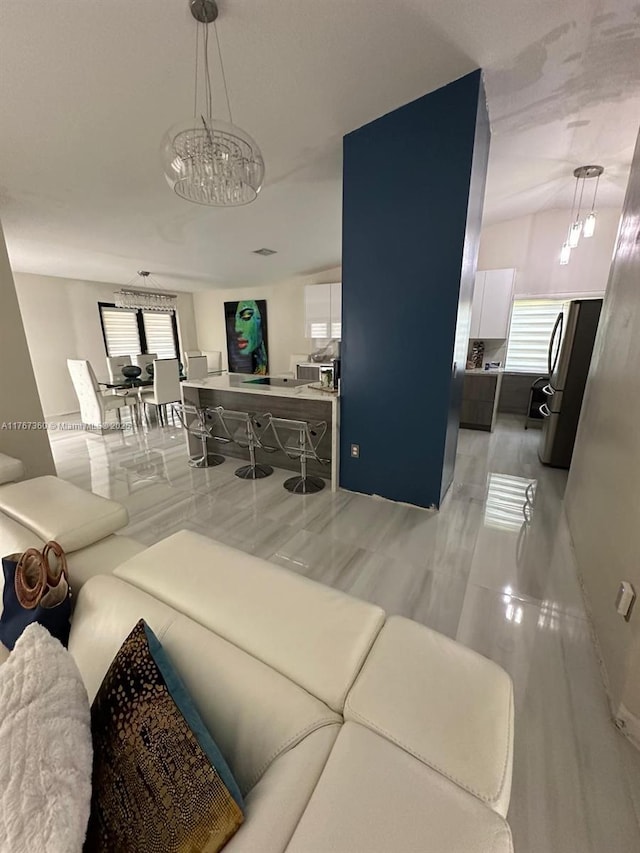 living room featuring a chandelier and lofted ceiling