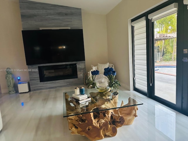 living room with wood finished floors and a glass covered fireplace