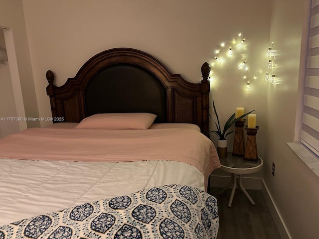bedroom with wood finished floors and baseboards
