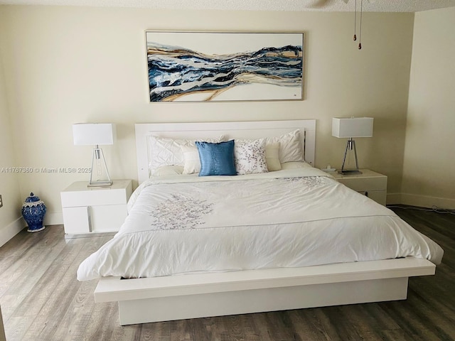 bedroom featuring baseboards and wood finished floors