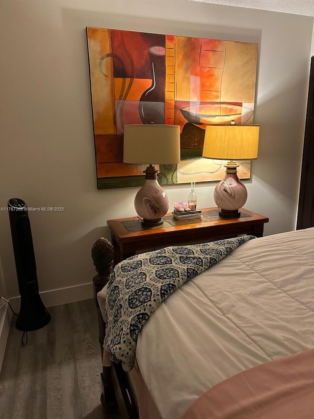bedroom with baseboards and wood finished floors