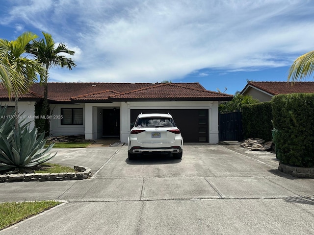 view of front of home with driveway, stucco siding, an attached garage, and a tile roof