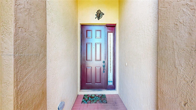 property entrance with stucco siding