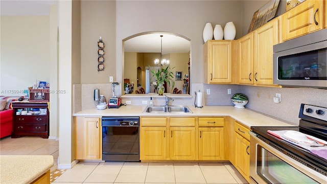 kitchen featuring a sink, stainless steel appliances, an inviting chandelier, light tile patterned floors, and light brown cabinets