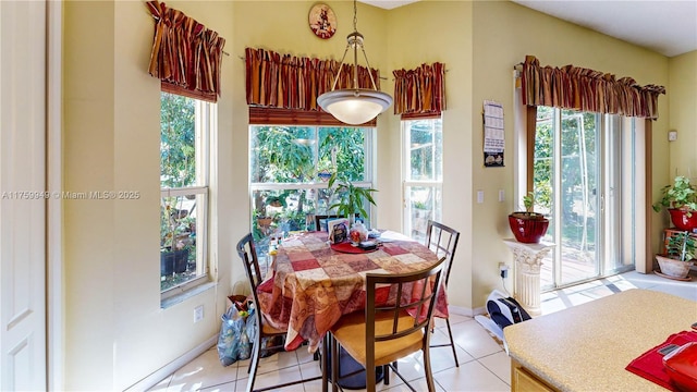 dining space featuring light tile patterned flooring and baseboards