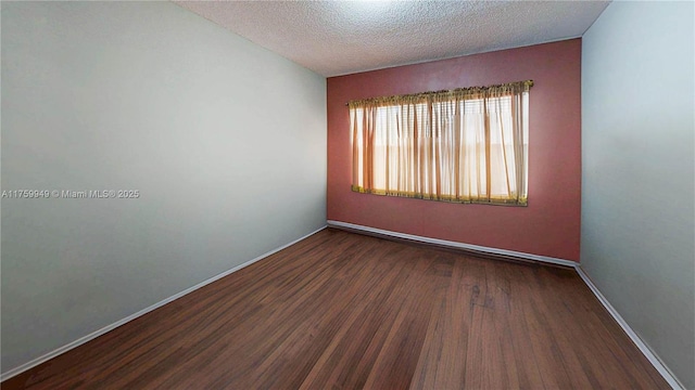 empty room featuring baseboards, a textured ceiling, and wood finished floors