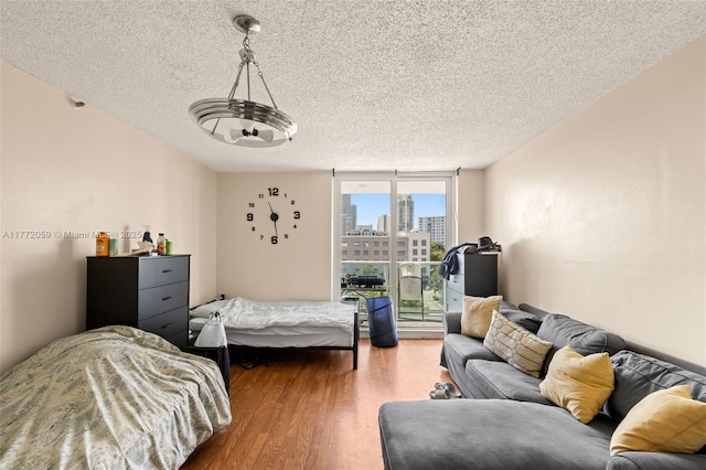 1035 W Ave Unit 507, Miami Beach, FL 33139 - bedroom with a textured ceiling, a view of city, wood finished floors, and expansive windows