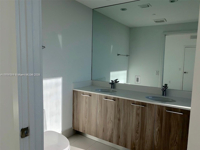 full bathroom featuring visible vents, a sink, toilet, and double vanity