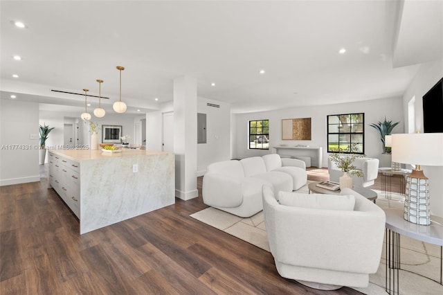 living area featuring baseboards, recessed lighting, and dark wood-type flooring