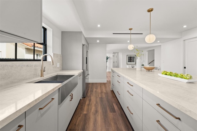 kitchen featuring dark wood-style flooring, a sink, recessed lighting, high end refrigerator, and decorative backsplash