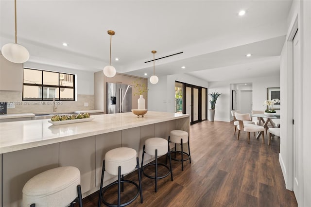 kitchen featuring a sink, tasteful backsplash, recessed lighting, high end fridge, and dark wood-type flooring