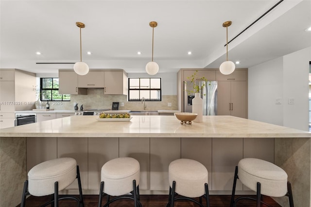 kitchen with a large island, decorative backsplash, a sink, and recessed lighting