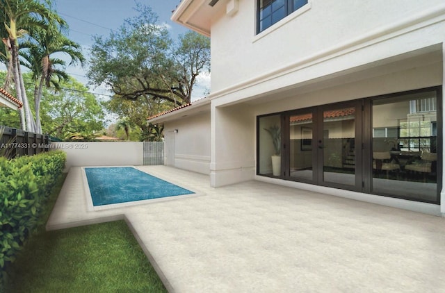 view of swimming pool featuring french doors, a patio area, and fence