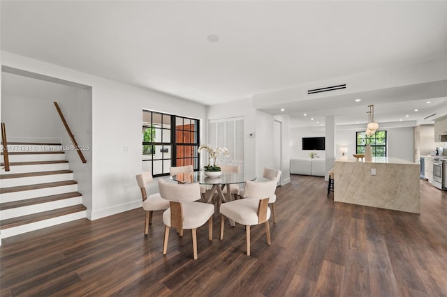 dining area with dark wood-style flooring, visible vents, a healthy amount of sunlight, and stairs