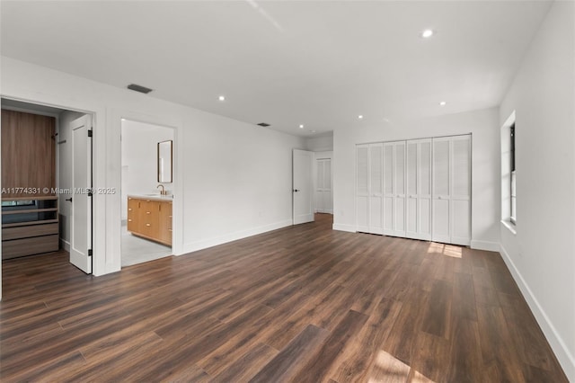 unfurnished bedroom with a closet, dark wood finished floors, baseboards, visible vents, and recessed lighting