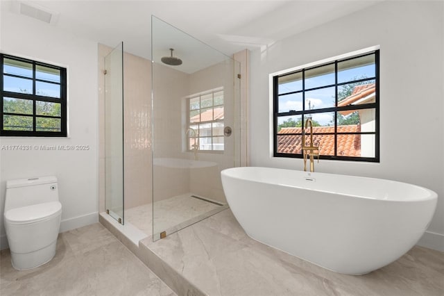 full bath with a healthy amount of sunlight, marble finish floor, and tiled shower