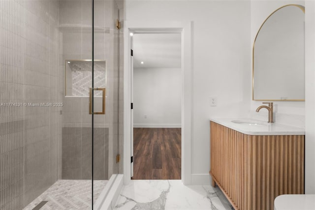 bathroom with a shower stall, vanity, baseboards, and marble finish floor