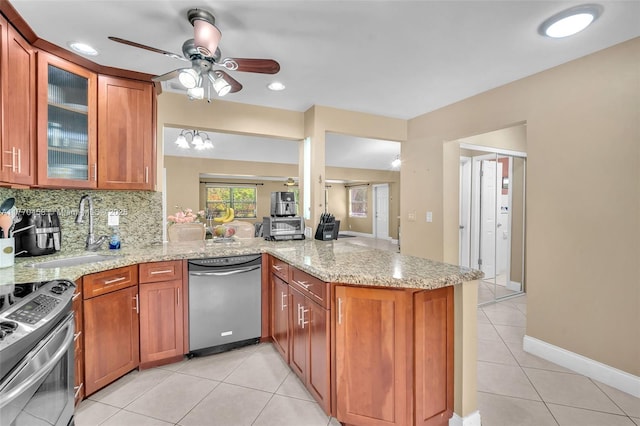 2343 SW 15th Pl, Deerfield Beach, FL 33442 - kitchen featuring a sink, a ceiling fan, light stone countertops, appliances with stainless steel finishes, and a peninsula