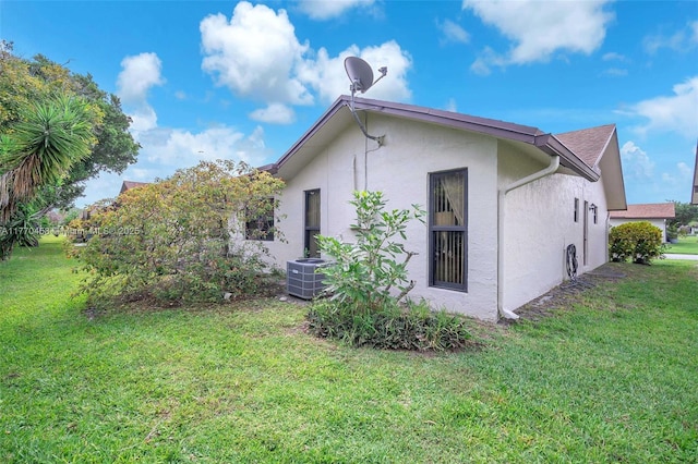2343 SW 15th Pl, Deerfield Beach, FL 33442 - view of property exterior featuring a lawn, cooling unit, and stucco siding