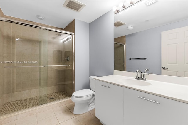 bathroom with tile patterned floors, a stall shower, toilet, and vanity
