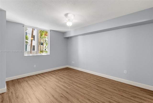 spare room with wood finished floors and baseboards