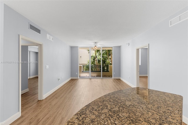 unfurnished room featuring light wood-style floors, ceiling fan, and baseboards