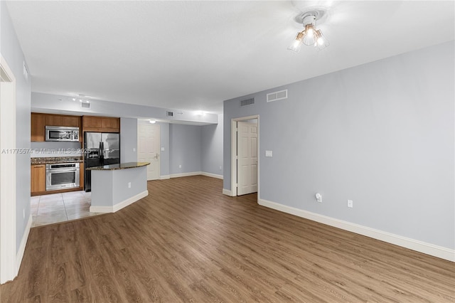 unfurnished living room featuring light wood finished floors and baseboards