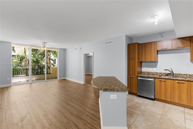 510 NW 84th Ave Unit 242, Plantation, FL 33324 - kitchen with stainless steel dishwasher, a sink, dark stone countertops, open floor plan, and brown cabinetry