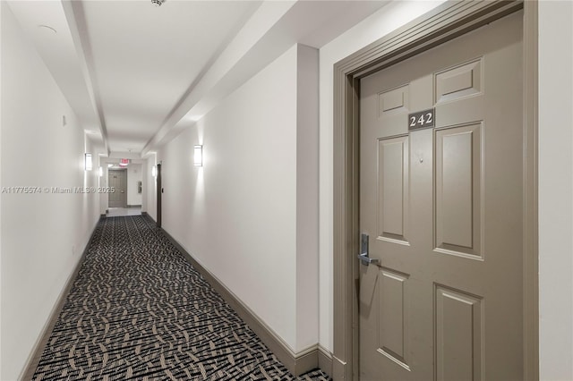 hallway featuring baseboards and carpet floors